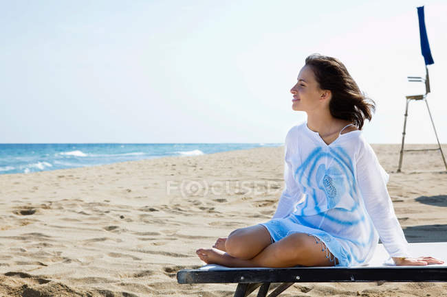 Joven mujer relajada en la playa - foto de stock