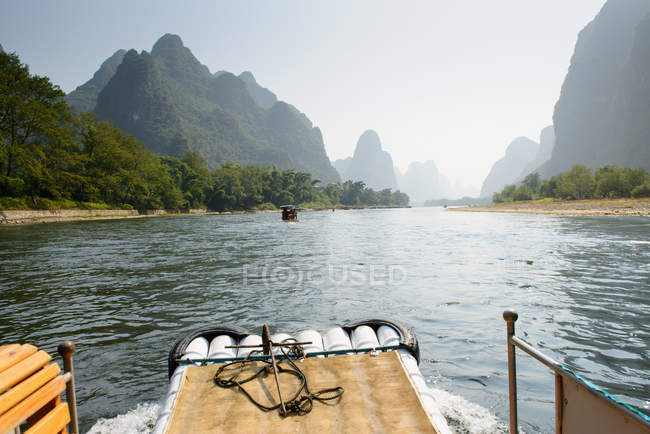 Barco de bambú navegando por el río - foto de stock