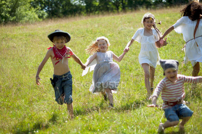 Дети в костюмах бегают по полю — стоковое фото