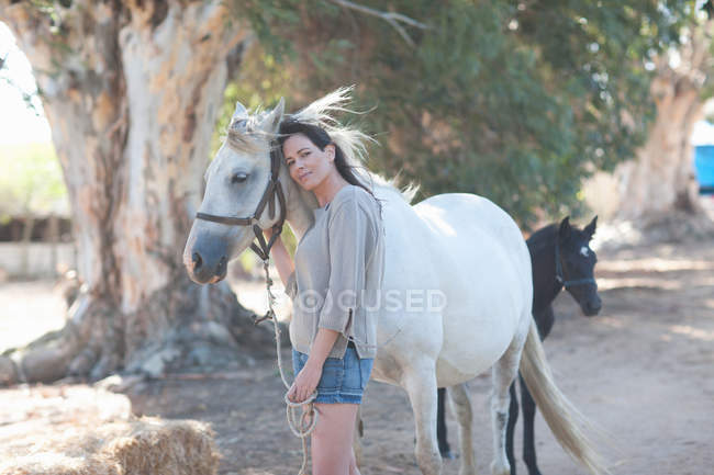 Donna appoggiata al collo del cavallo — Foto stock