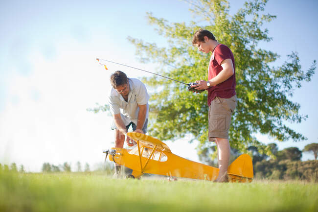 Hommes jouant avec jouet avion dans le parc — Photo de stock