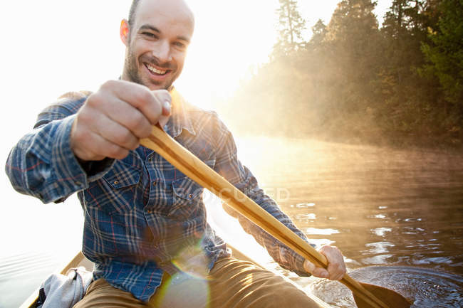 Man rowing canoe — Stock Photo