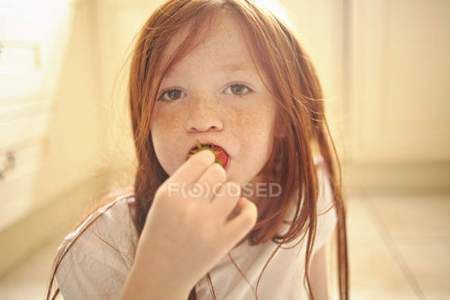 Portrait of girl eating strawberry — Stock Photo