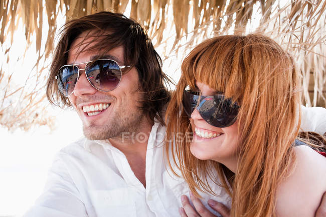 Couple under sunshade — Stock Photo