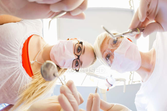 Стоматологи, работающие с зубами пациентов — стоковое фото