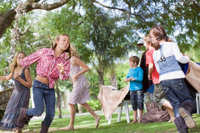 Niños jugando juntos en el patio trasero - foto de stock