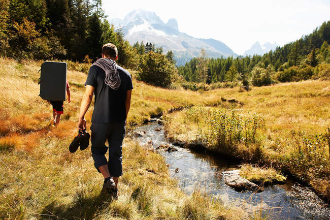 Two men hiking by river — Stock Photo