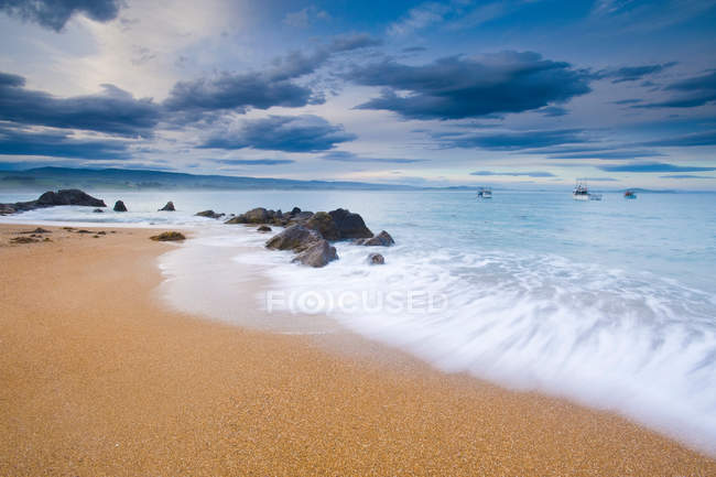 Хвилі миття на піщаному пляжі — стокове фото