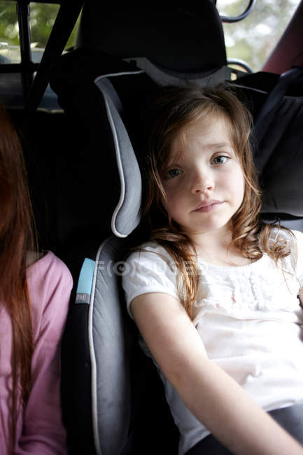 Portrait of girl sitting in car seat — Stock Photo