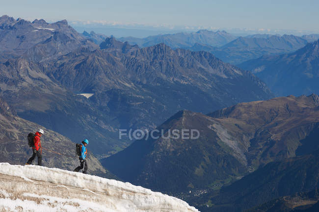 Two people walking on mountain — Stock Photo