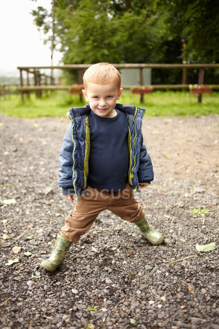Menino de pé no caminho de cascalho — Fotografia de Stock