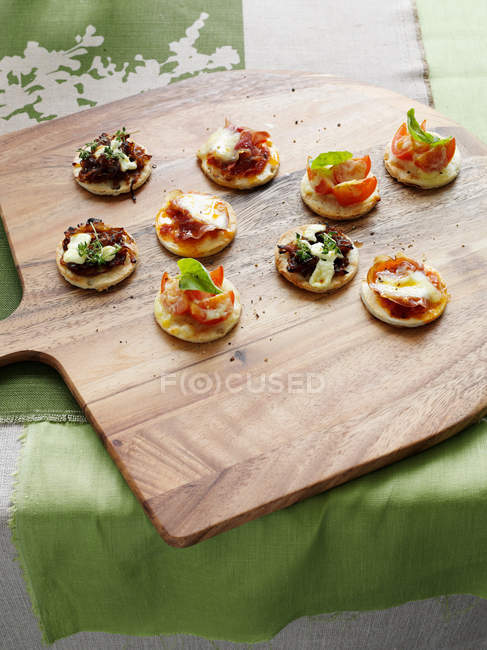 Tray of crackers with toppings on table — Stock Photo