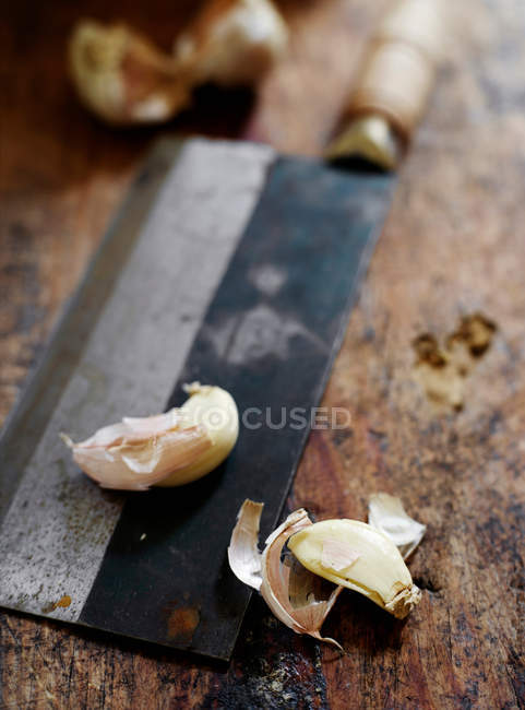Dientes de ajo en cuchillo de carnicero - foto de stock