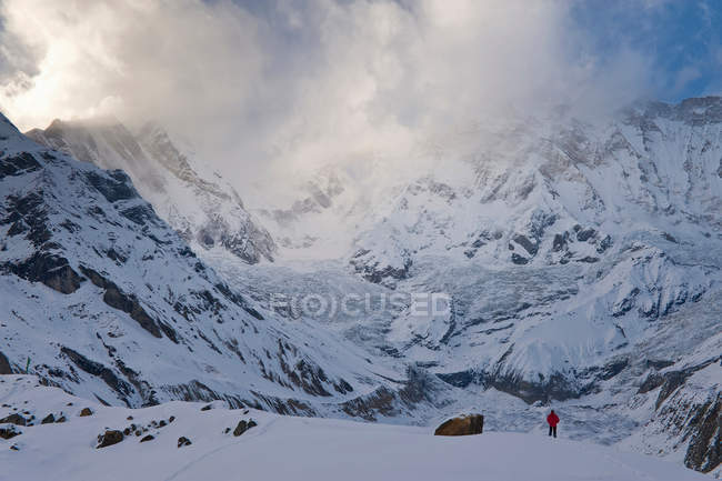 Caminhante na paisagem montanhosa nevada — Fotografia de Stock