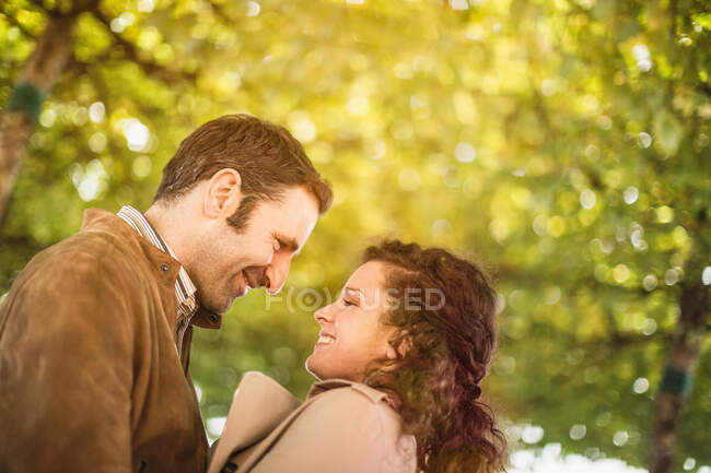 Casal sorrindo um para o outro no parque — Fotografia de Stock