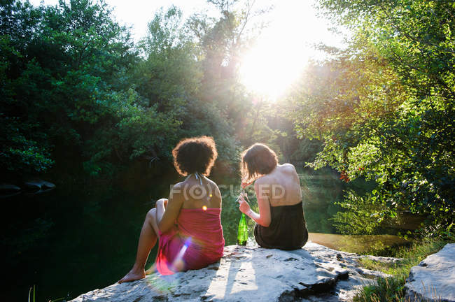 Two women relaxing by river — Stock Photo