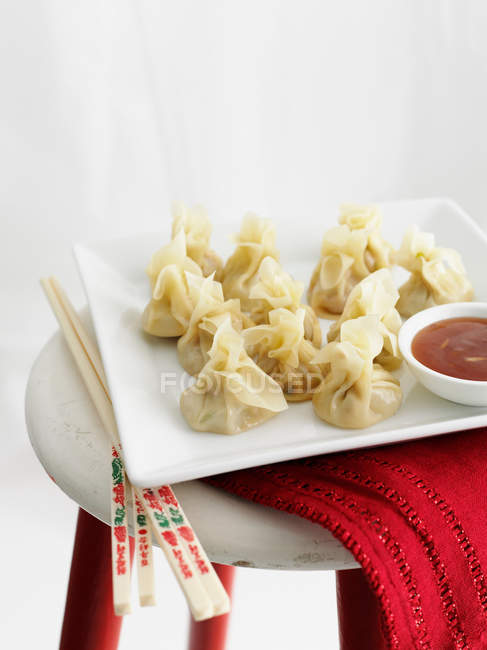 Plate of dumplings with dipping sauce — Stock Photo