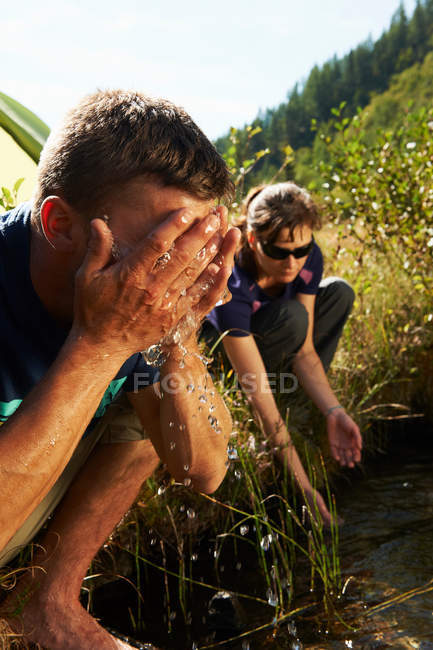 Couple washing in river stream — Stock Photo