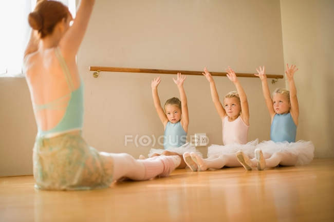 Девушки, растянувшиеся в балетном классе — стоковое фото