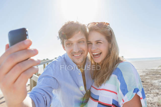 Пара фотографирует себя на пляже — стоковое фото