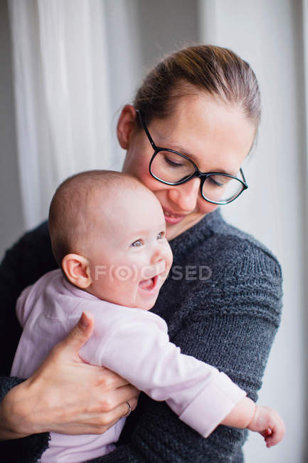 Мама держит улыбающегося ребенка — стоковое фото