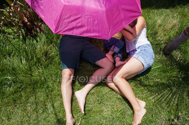 Genitori e figlio sdraiati sull'erba — Foto stock