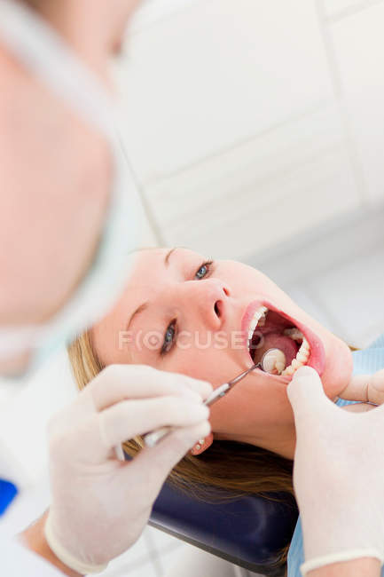 Dentist working on patients teeth — Stock Photo