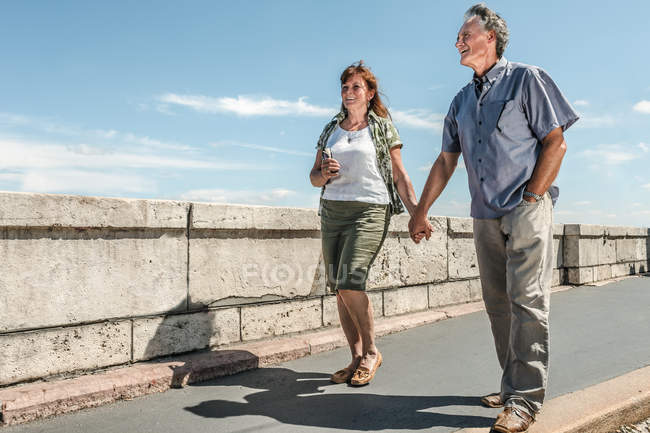 Пара держась за руки на мосту — стоковое фото