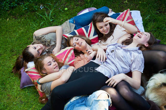 Teenage girls laying on pillows outdoors — Stock Photo