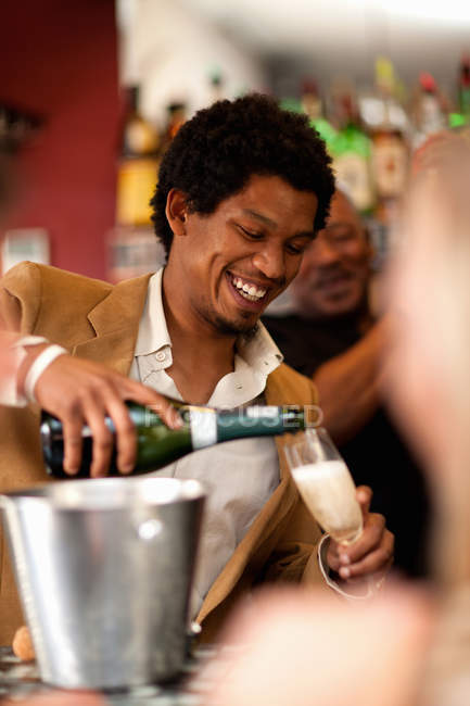 Barman versant du champagne au bar — Photo de stock