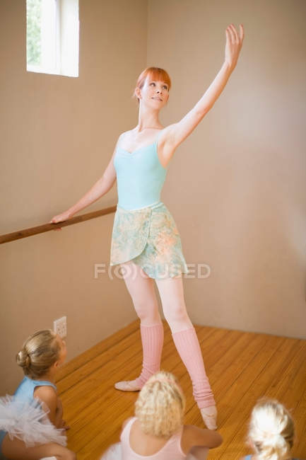 Ballet teacher posing at barre — Stock Photo