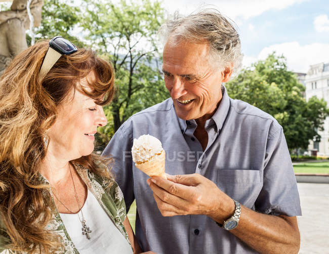 Мужчина предлагает жене мороженое — стоковое фото