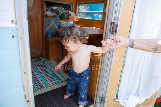 Отец помогает сыну в дверях — стоковое фото