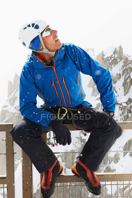 Uomo che indossa il casco da arrampicata guardando in alto — Foto stock