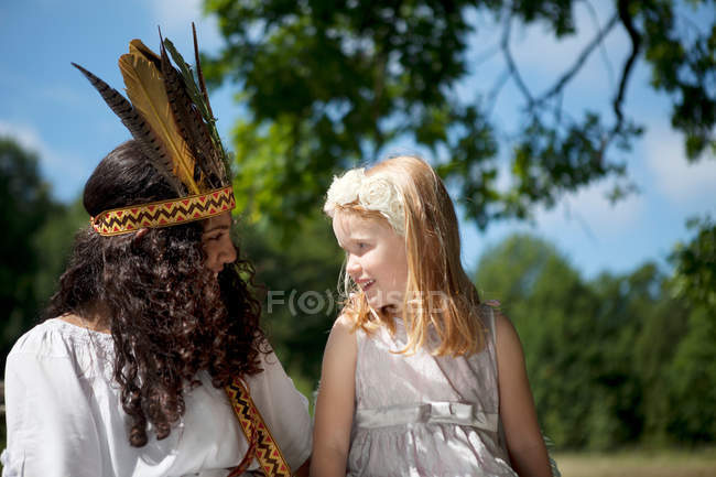 Girls in costumes sitting outdoors — Stock Photo