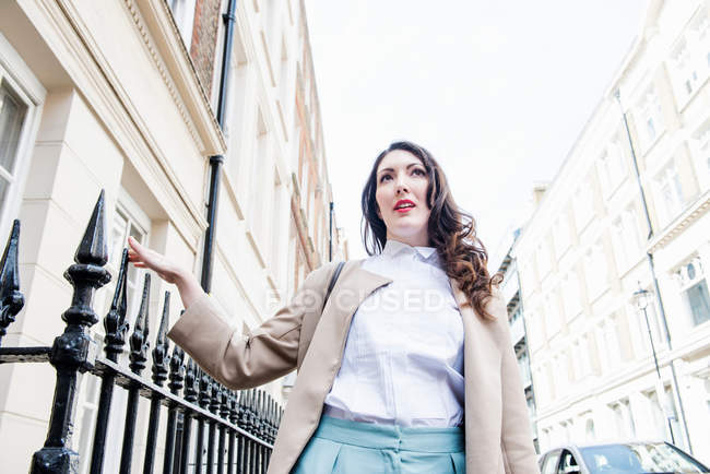 Femme touchant balustrades sur la rue — Photo de stock