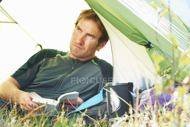 Man laying and holding book — Stock Photo