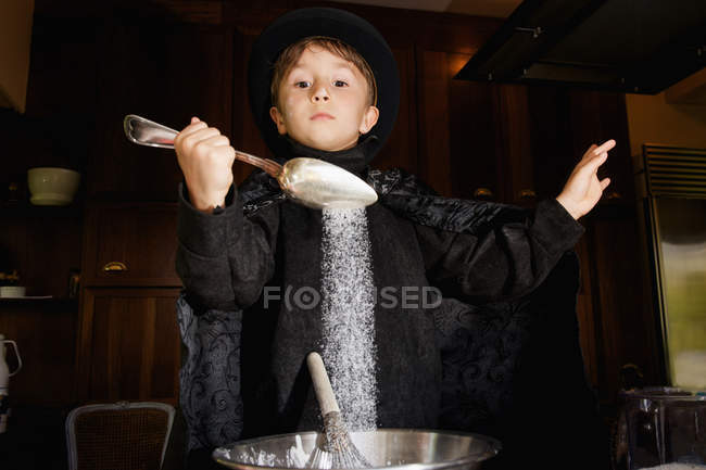 Boy magician cooking in kitchen — Stock Photo