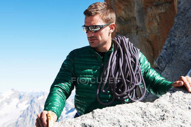 Альпініст з альпіністською мотузкою над плечем — стокове фото