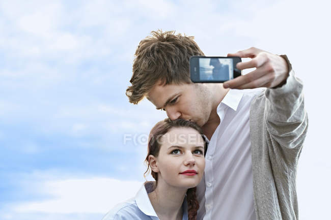 Пара, делающая селфи со смартфоном — стоковое фото