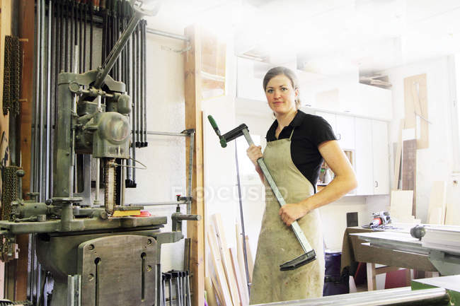Feminino carpinteiro segurando ferramenta — Fotografia de Stock