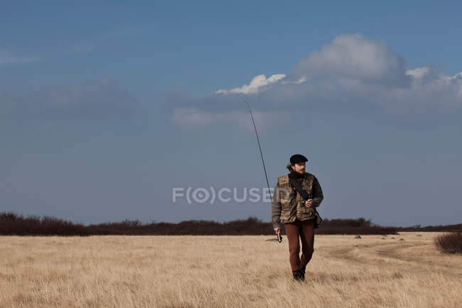 Man carrying fishing rod — Stock Photo