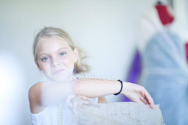 Menina sorrindo segurando padrão designer — Fotografia de Stock