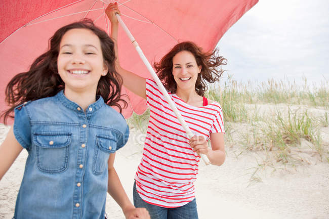 Мать и дочь несут зонтик — стоковое фото