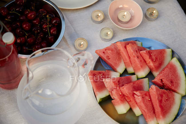 Watermelon slices and cherries on table — Stock Photo