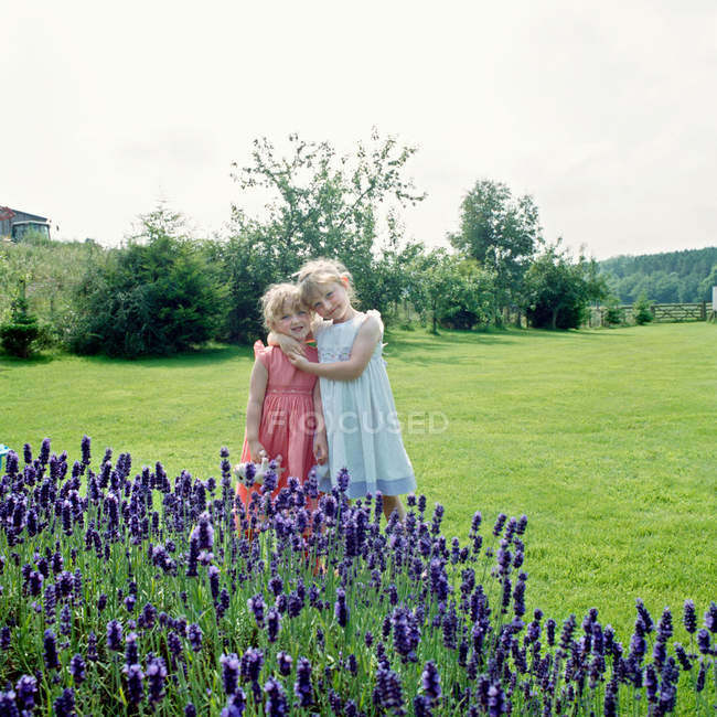 Two girls hugging in garden — Stock Photo