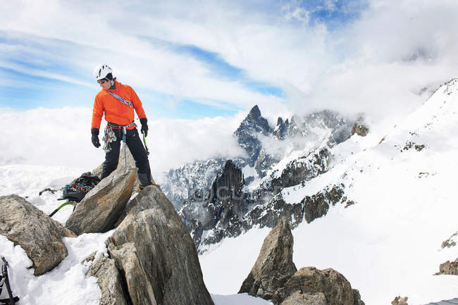 Hombre de pie en la roca en las montañas - foto de stock