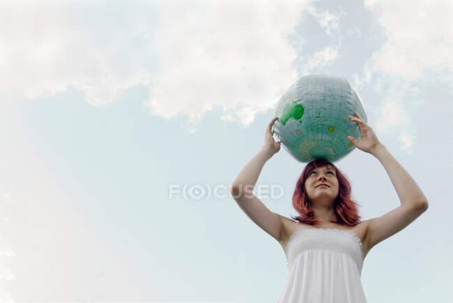 Jeune femme avec globe — Photo de stock