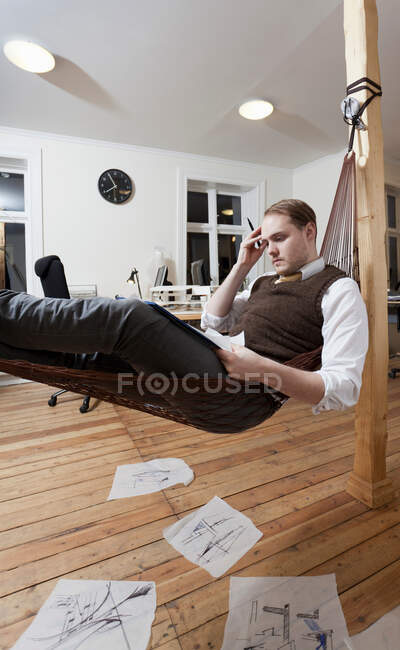 Businessman taking notes in hammock — Stock Photo