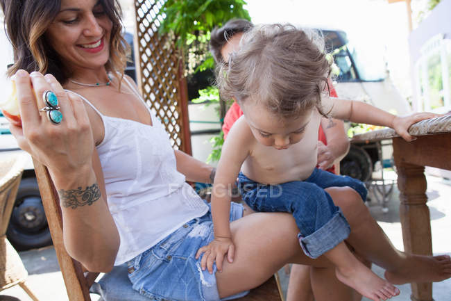 Niño sentado en la madre vueltas - foto de stock
